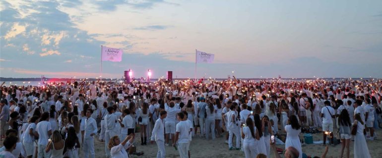 Tout le monde en blanc, les pieds dans le sable, avec le Bassin et son magnifique coucher de soleil en toile de fond ©JC Lauchas